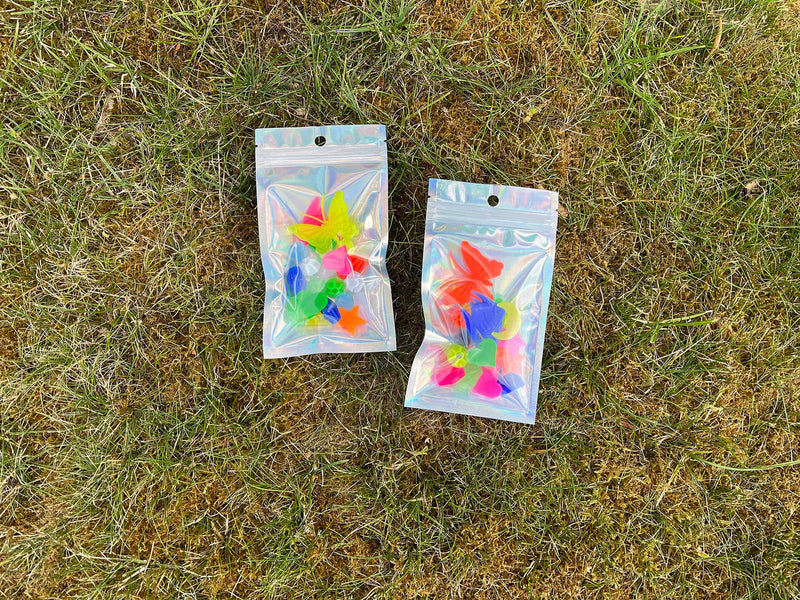 Zwei Packungen bunte Fahrradspeichenclips auf dem Gras