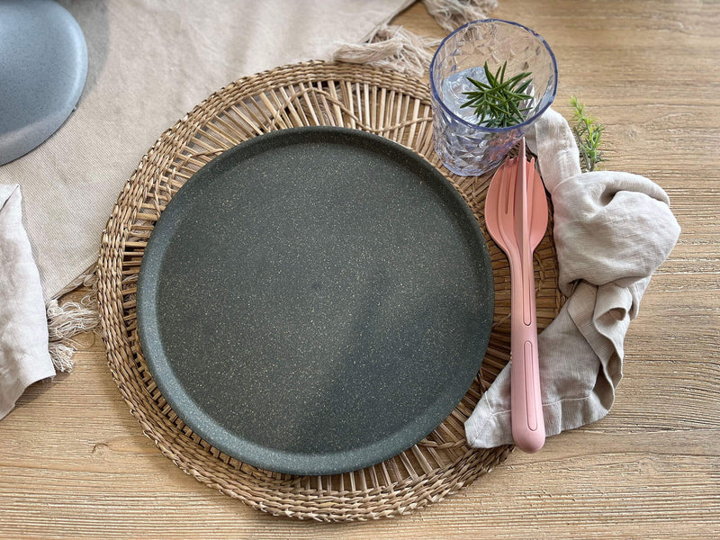 Besteckset Apricot Farbe neben einem Teller auf einem TIsch