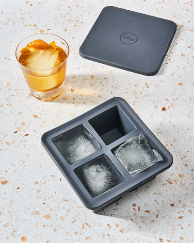 ein wiederverwendbarer XL-Eiswürfelbehälter auf der Küchenarbeitsplatte, mit einem Getränk