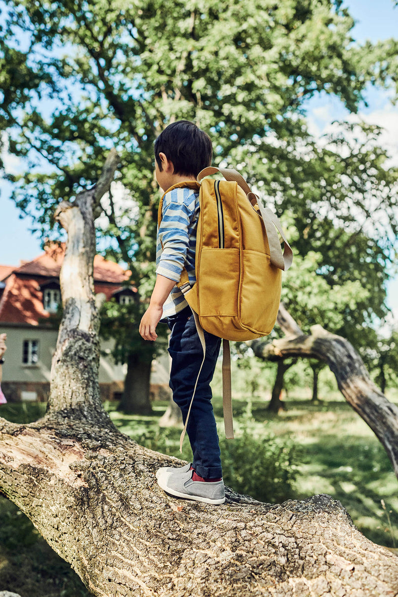 Samt Rucksack gelb Junge auf einem Baum
