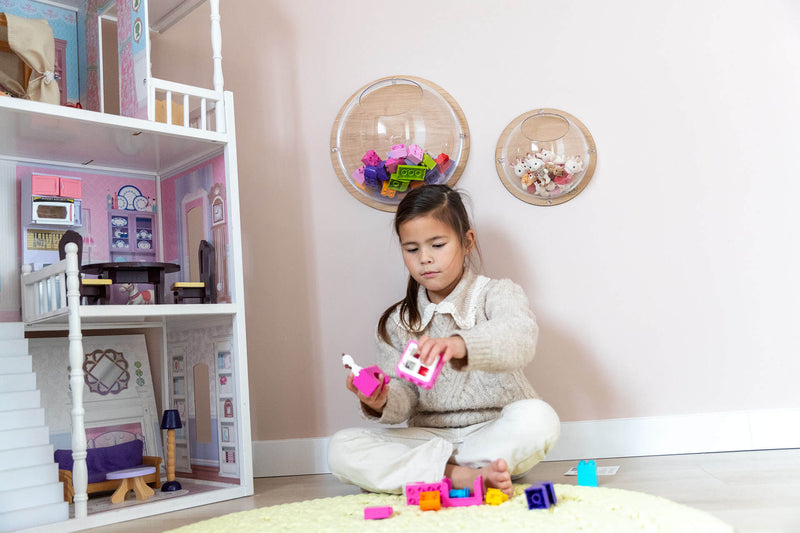Mädchen spielt im Kinderzimmer, Wandkugeln hängen an der Wand