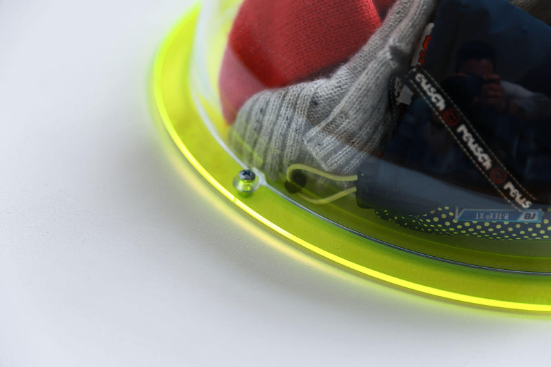 Halbkugel aus klarem Acryl mit einem transparenten neongrünen Hintergrund, gefüllt mit winterlichen Accessoires - Nahaufnahme