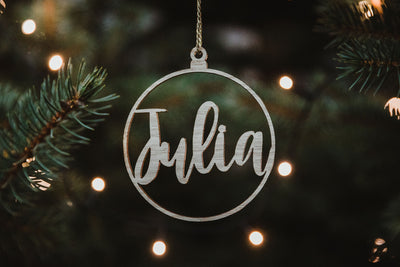 Weihnachtsbaumschmuck aus Holz mit dem Namen Julia hängend auf einem Weihnachtsbaum