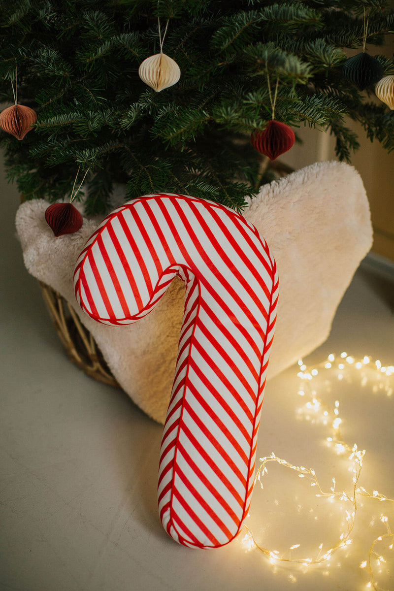 Kissen im Form einer Zuckerstange unter dem Weihnachtsbaum