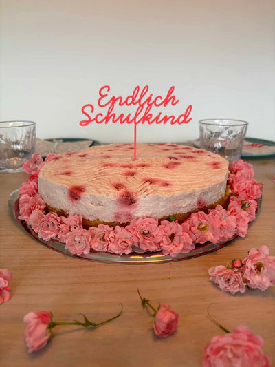 Endlich Schulkind Caketopper aus pinkem Acryl auf einem schönen pinken Kuchen auf einem Geburtstagstisch