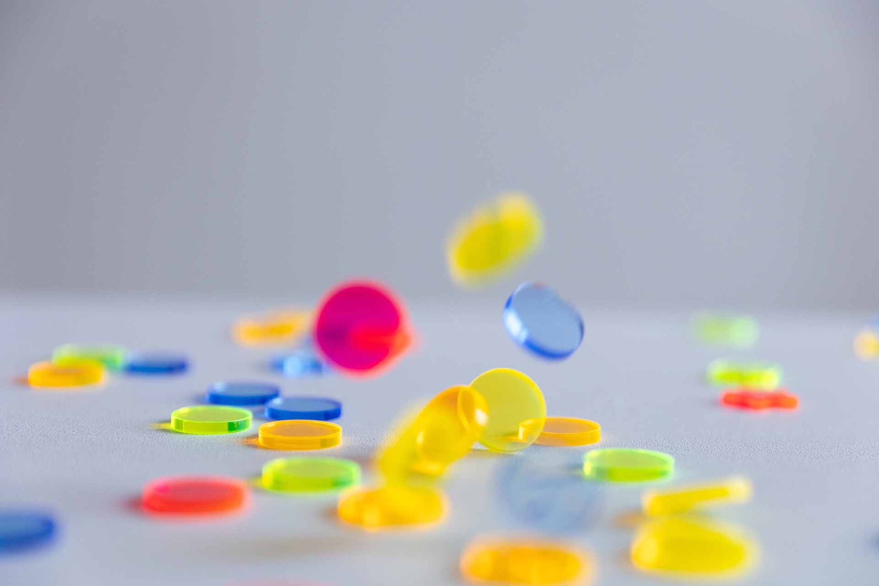 Neon-Acryl-Konfetti, das auf einen weißen Tisch fällt