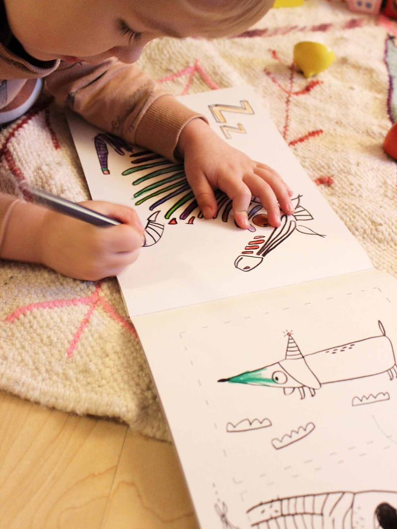 Ein Kind malt in einem ABC Malbuch