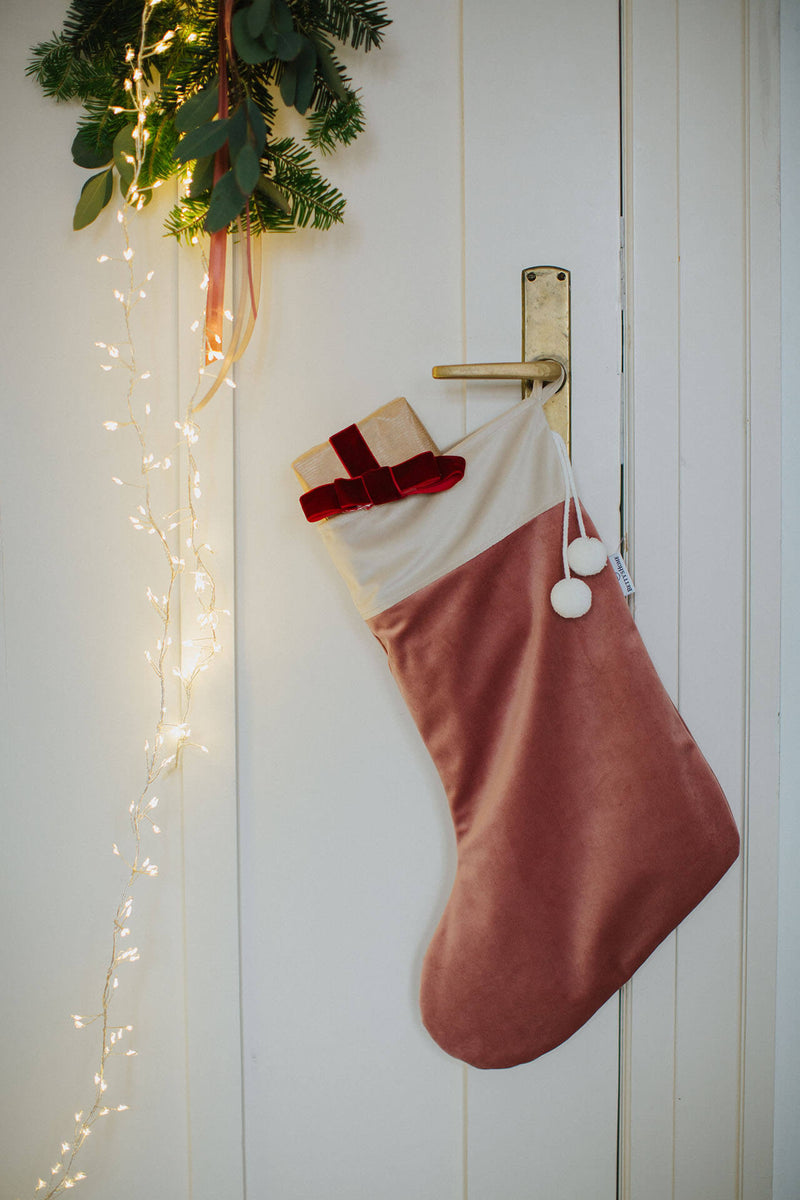 Altrosa Weihnachtsstrumpf aus Samt hängt an einer Tür