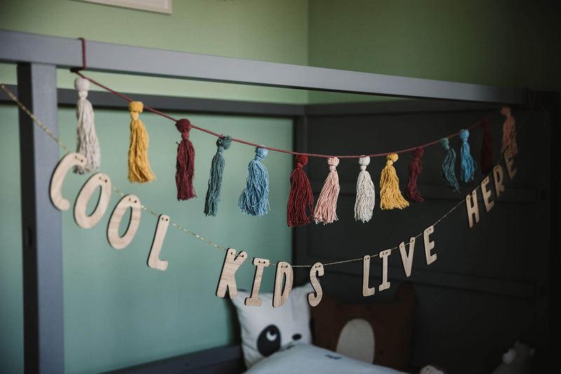 "Cool Kids Live Here" Holzgirlande hängend am Kinderbett im Kinderzimmer