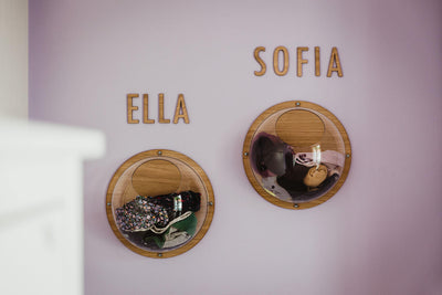 Zwei Wandkugeln gefüllt mit Sachen, oben zwei Namensschilder aus Holz, "Sofia" und "Ella"