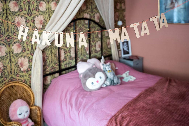 Hakuna Matata Holzgirlande hängend im Mädchenzimmer, über das pinke Bett