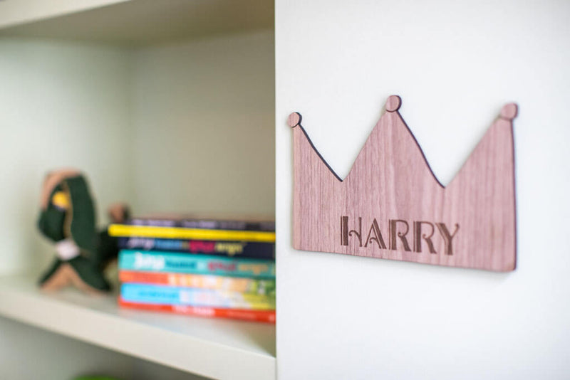 Holzkrone HARRY an der Wand neben Büchern