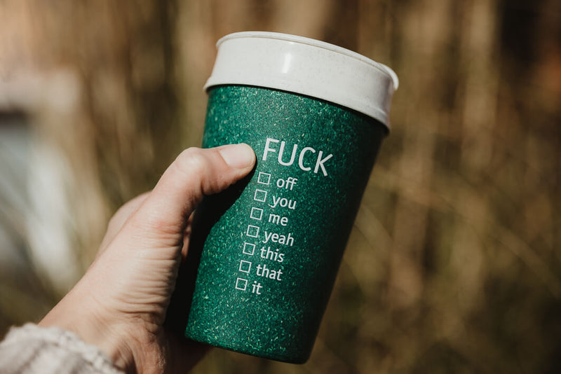 Fuck To Go Kaffeebecher draußen in der Hand