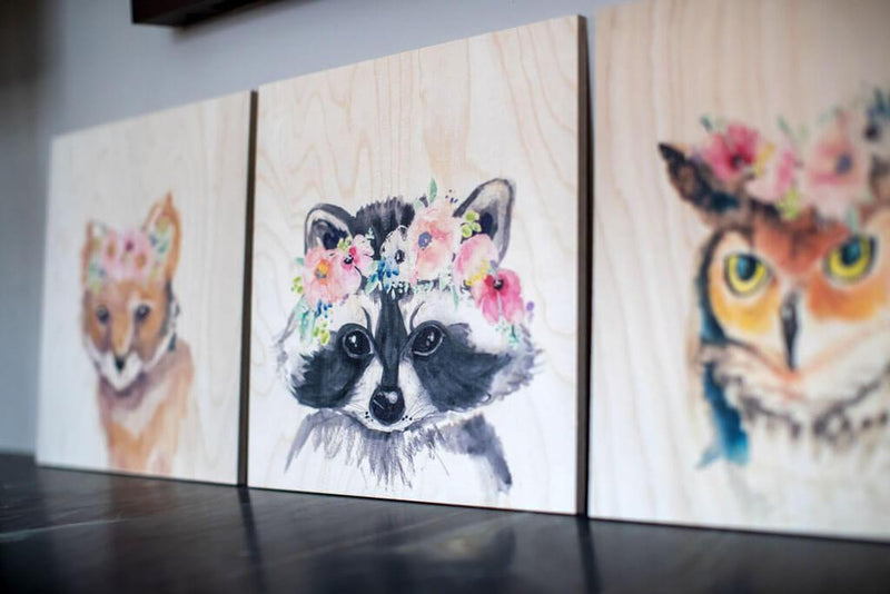 Waldwunder Waschbär Kunstdruck auf Holz, lehnend an der Wand neben drei anderen Bildern, Fuchs , Hase und Eule